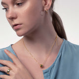 Frau mit Gold Kette mit Ring Anhänger und bunten kleinen Steinen