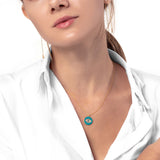 Frau mit weissem Hemd und Gold Kette mit Türkis farbenem Augen Anhänger