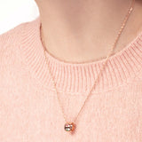 Frau mit Rosegold Kette mit Ring Anhänger und bunten kleinen Steinen